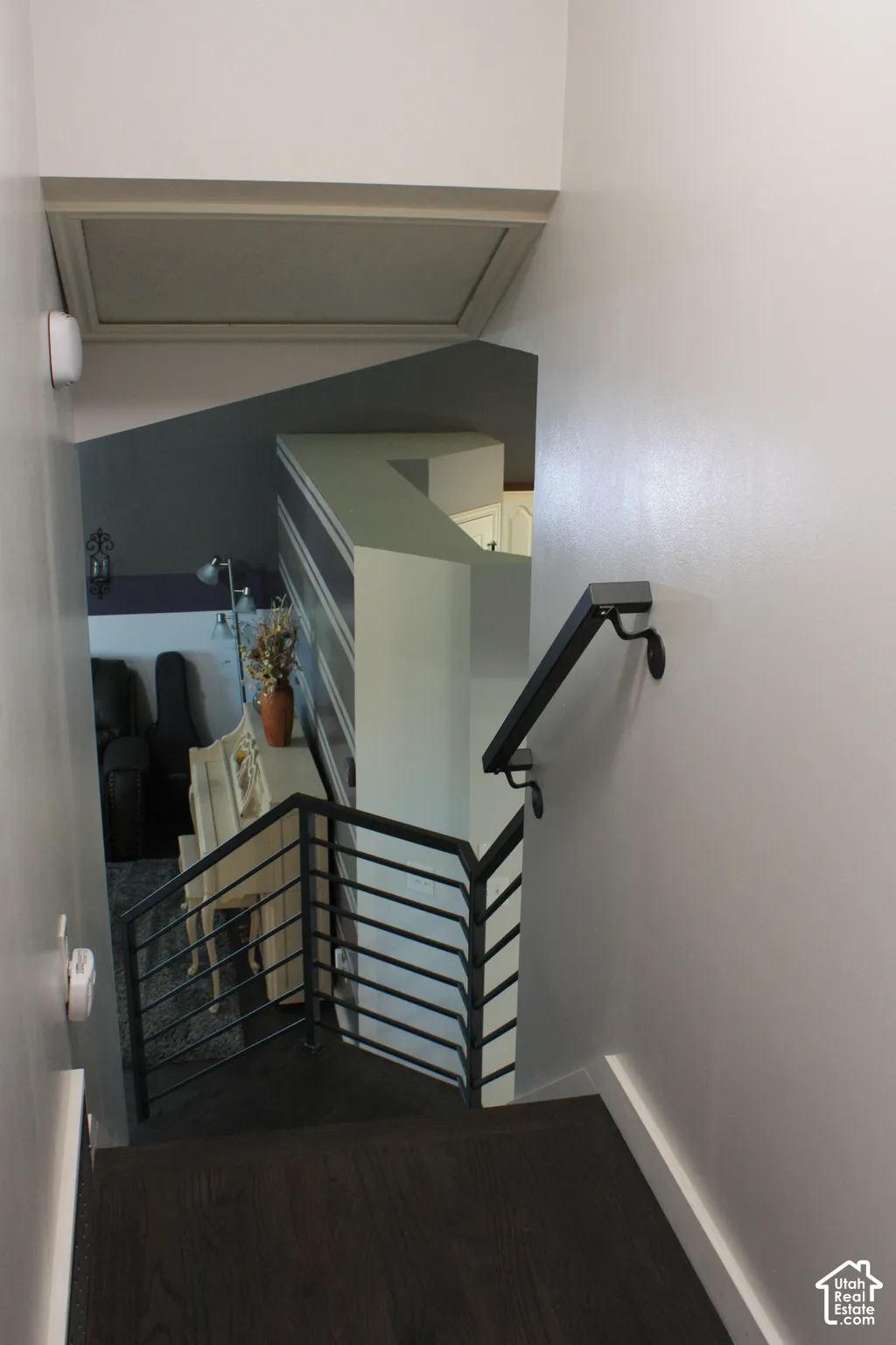 Dark wood-finish flooring with a modern metal railing