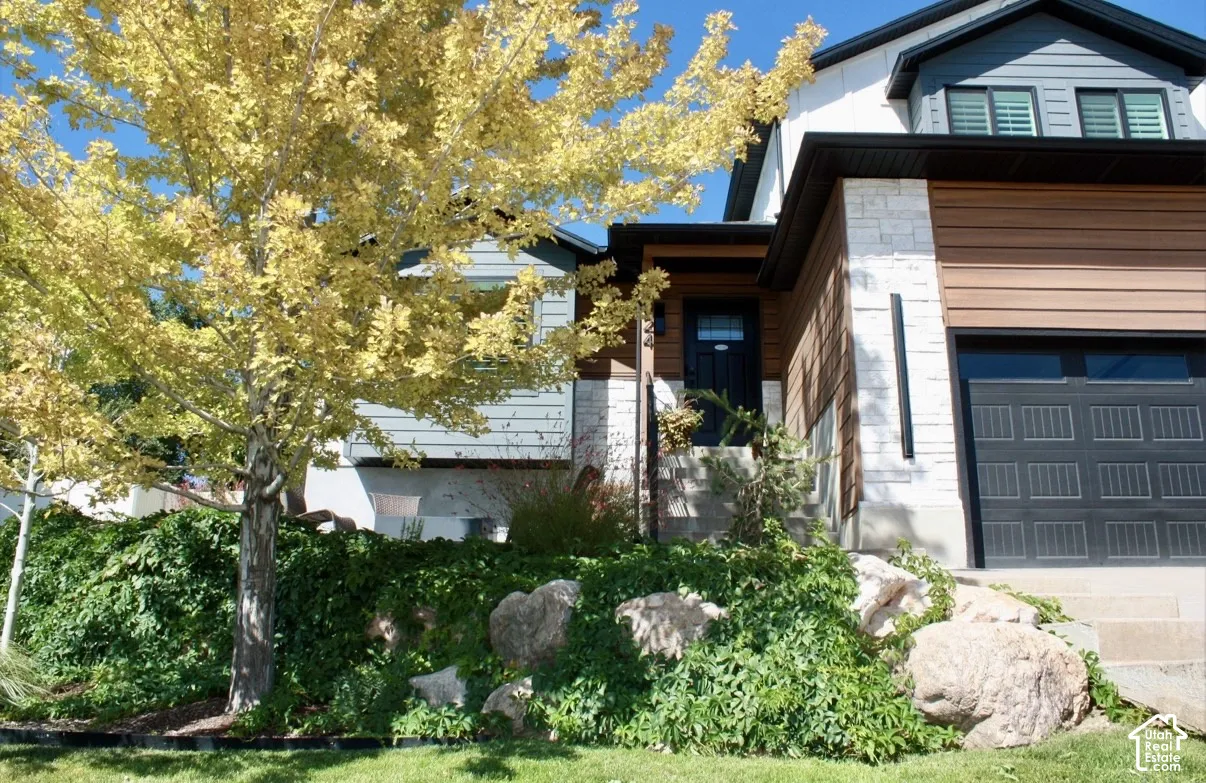 Multi-material facade featuring horizontal wood-tone siding and stone accents