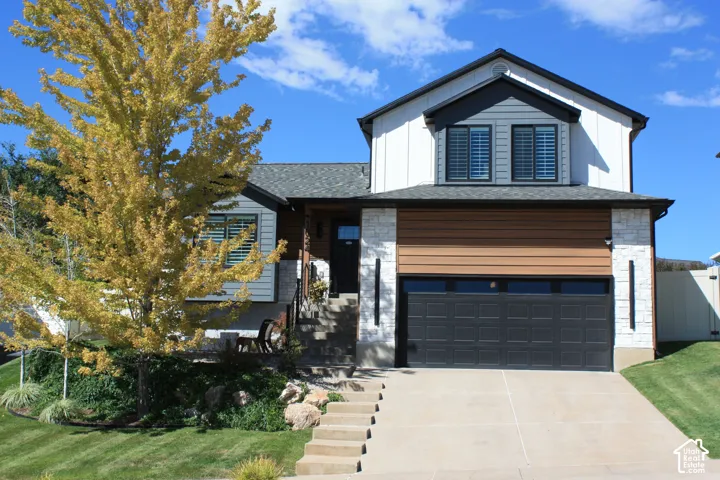 Contemporary facade with white vertical siding, horizontal wood-finish siding, and stone accents