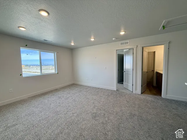 Spacious primary living area featuring recessed ceiling lighting, carpet flooring, and multiple entry points