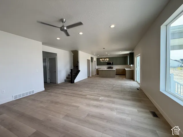 Open-concept living space featuring wood-finish flooring, recessed lighting, and a modern ceiling fan