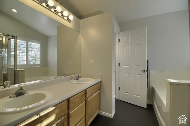Dual vanity with integrated sinks, wood-finish cabinetry, and an expansive mirror