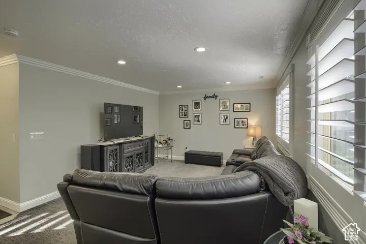 Recessed ceiling lighting, crown molding, light-toned wall finishes, carpeted flooring, and plantation shutters