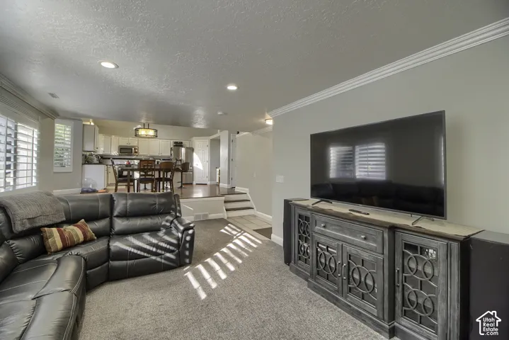 Recessed lighting, crown molding, white window shutters, and a raised dining area with wood-finish flooring