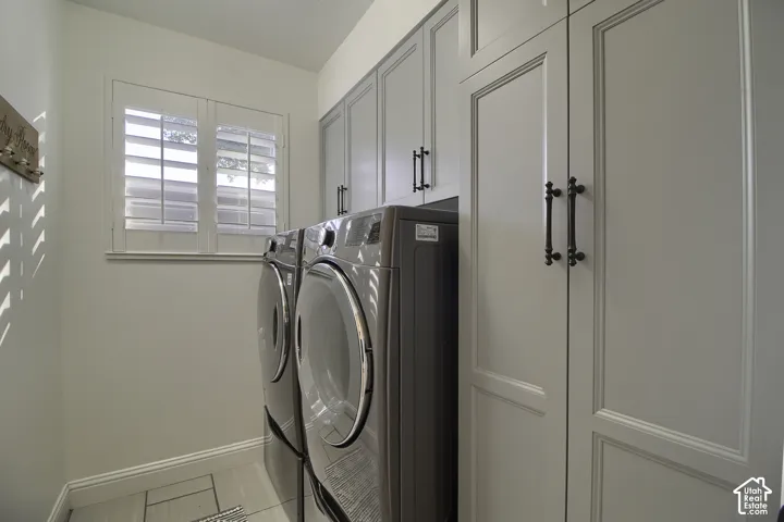 Built-in cabinetry with panel detailing, white plantation shutters, and light-toned tile flooring