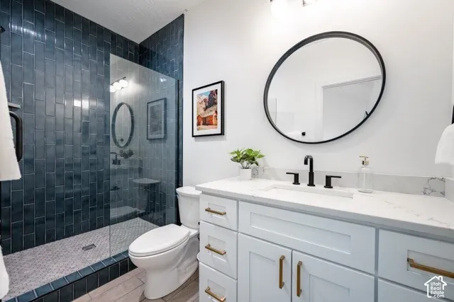 Shower with blue subway tile surround and clear glass enclosure