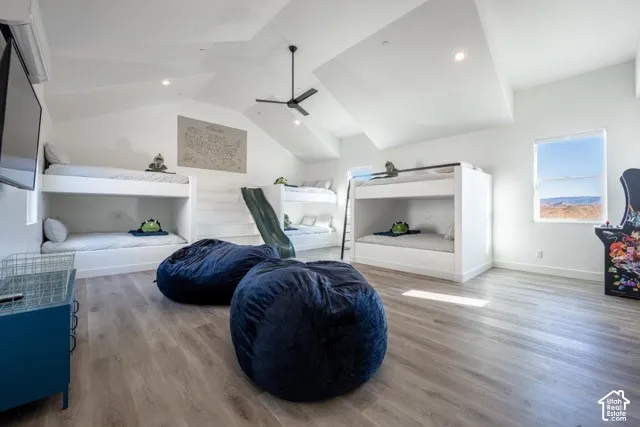 Vaulted ceilings with recessed lighting, wood-finish flooring, built-in bunk beds, ceiling fan, and a window for natural light