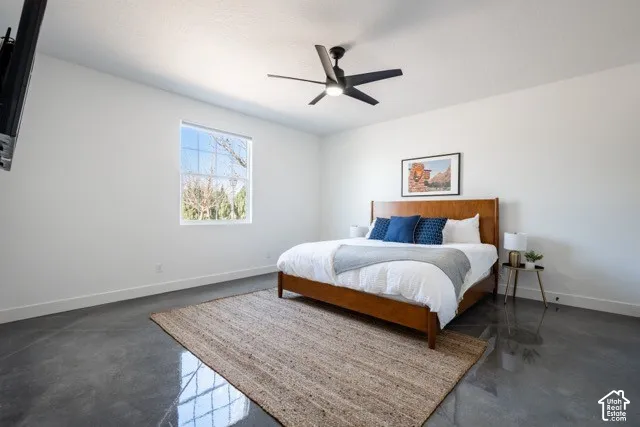 Polished concrete flooring, a large window, and a ceiling fan with integrated lighting