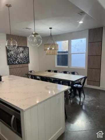 Kitchen island with a light-toned countertop, integrated microwave, and white paneled base