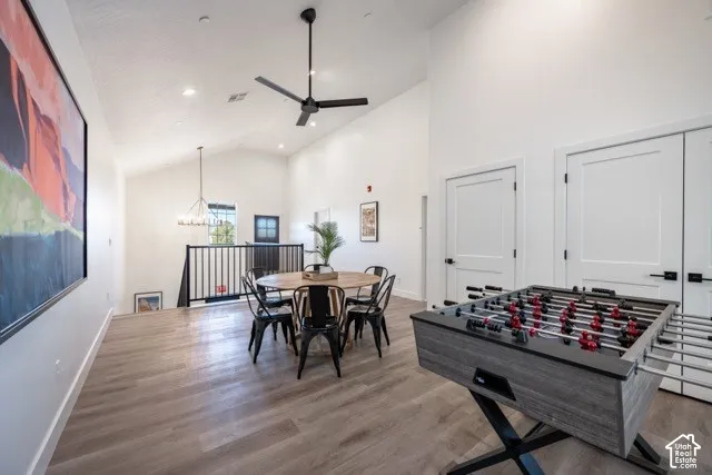 Vaulted ceilings, wood-finish flooring, recessed lighting, and black ceiling fan