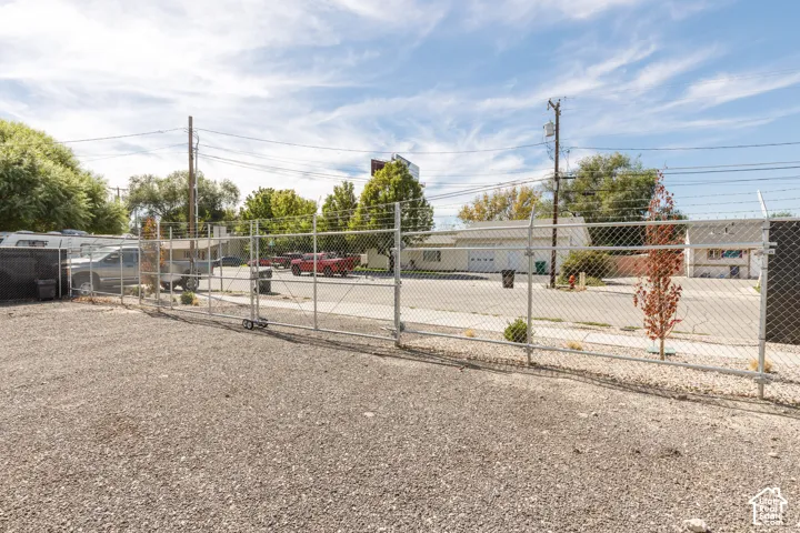Gravel lot with perimeter chain-link fencing, including a rolling gate
