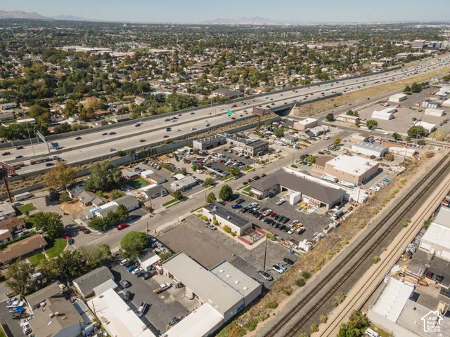Extensive commercial property featuring multiple structures, paved parking areas, and convenient access to a multi-lane highway and railway lines