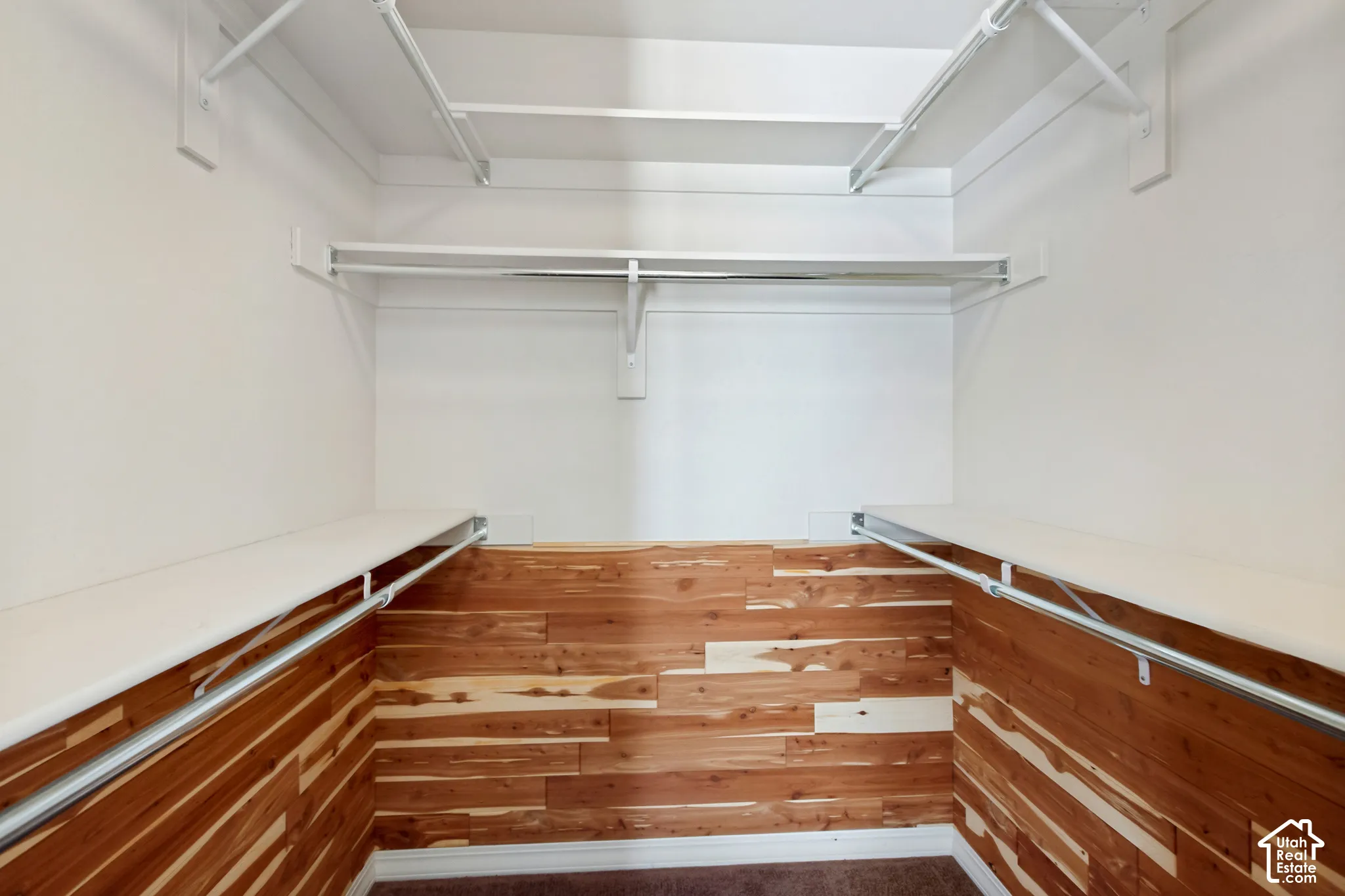 Built-in white shelving, integrated hanging rods, and wood-finish wall panels