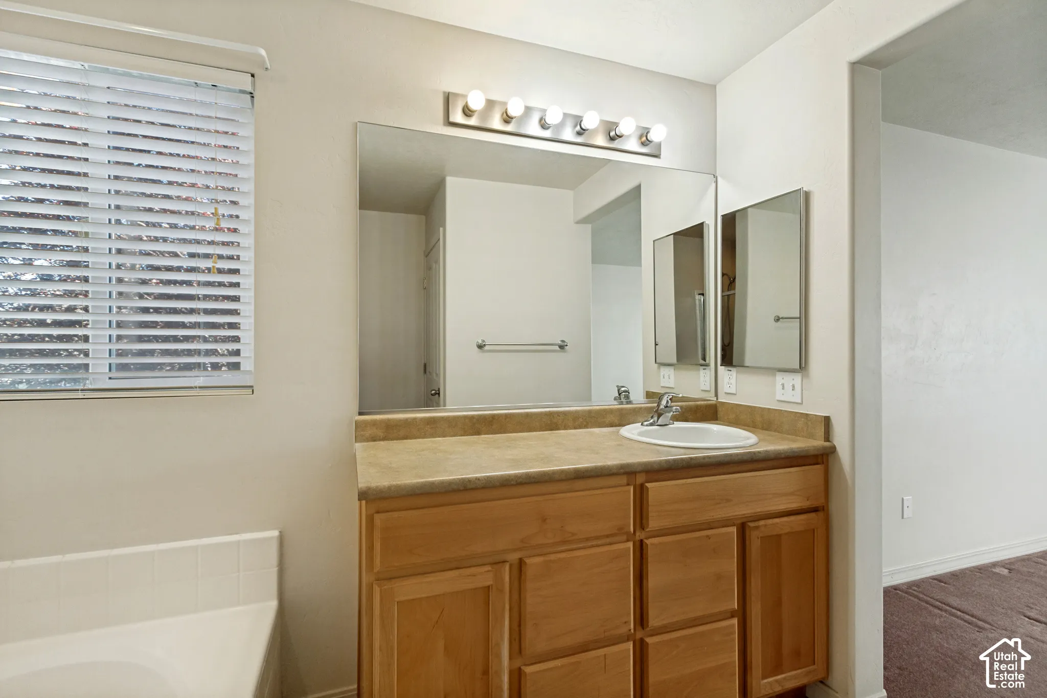 Single vanity with wood-finish cabinetry and an integrated sink