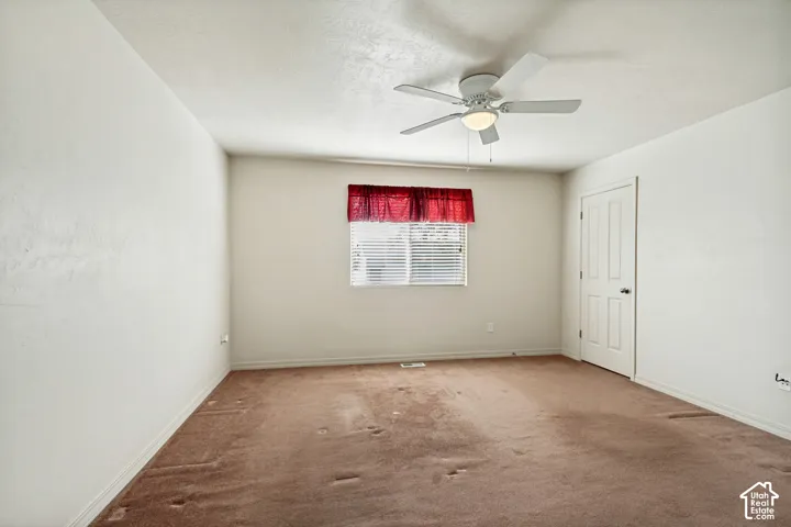 White-painted walls, a ceiling fan with integrated lighting, a window with horizontal blinds, and a white interior door