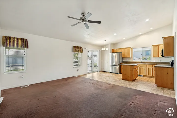 Open-concept living area with vaulted ceilings, recessed lighting, and a ceiling fan