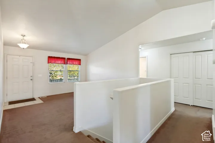 Entryway with tile flooring, vaulted ceiling, and two windows