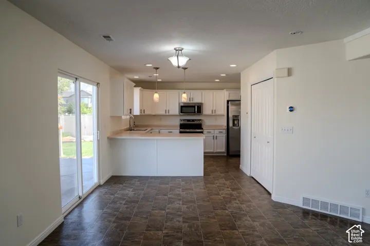 Kitchen featuring white cabinetry, stainless steel appliances, a breakfast bar, and recessed lighting