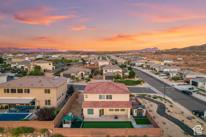 Two-story exterior with a tile roof, private backyard with artificial turf, and a storage shed