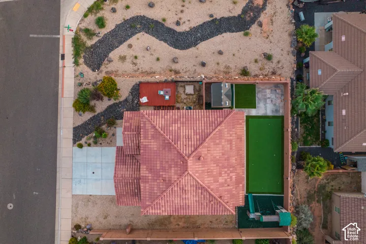 Red tiled roof, desert landscaping, concrete driveway, fenced yard, artificial turf putting green