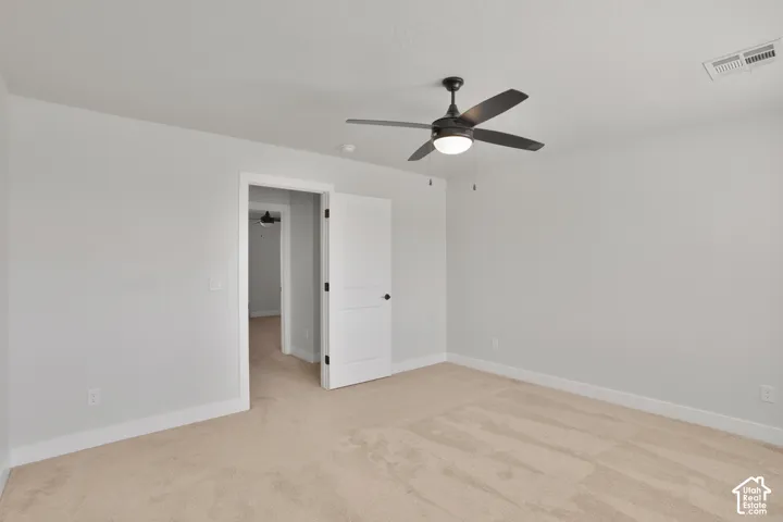 Bedroom 4. Neutral wall colors, plush carpeting, ceiling fan with integrated lighting, and white trim