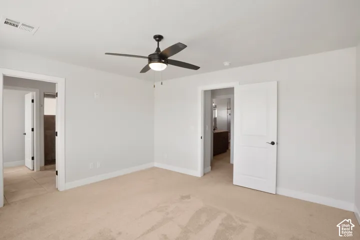 Carpeted flooring, ceiling fan with integrated lighting, and white paneled doors