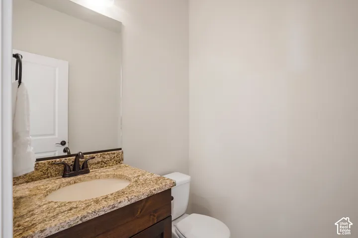 Downstairs guest bath. Vanity with a granite countertop, undermount sink, and bronze-finish faucet