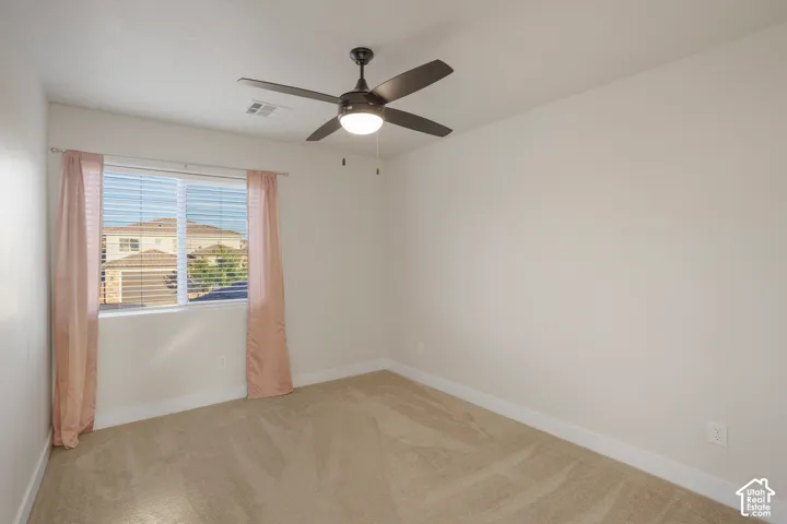 Bedroom 2. Carpeted flooring, window with blinds, ceiling fan with integrated lighting, and neutral wall paint