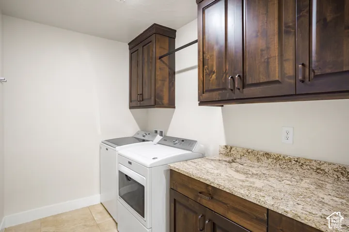 Laundry area featuring overhead cabinetry, a countertop, and wood-finish lower cabinetry