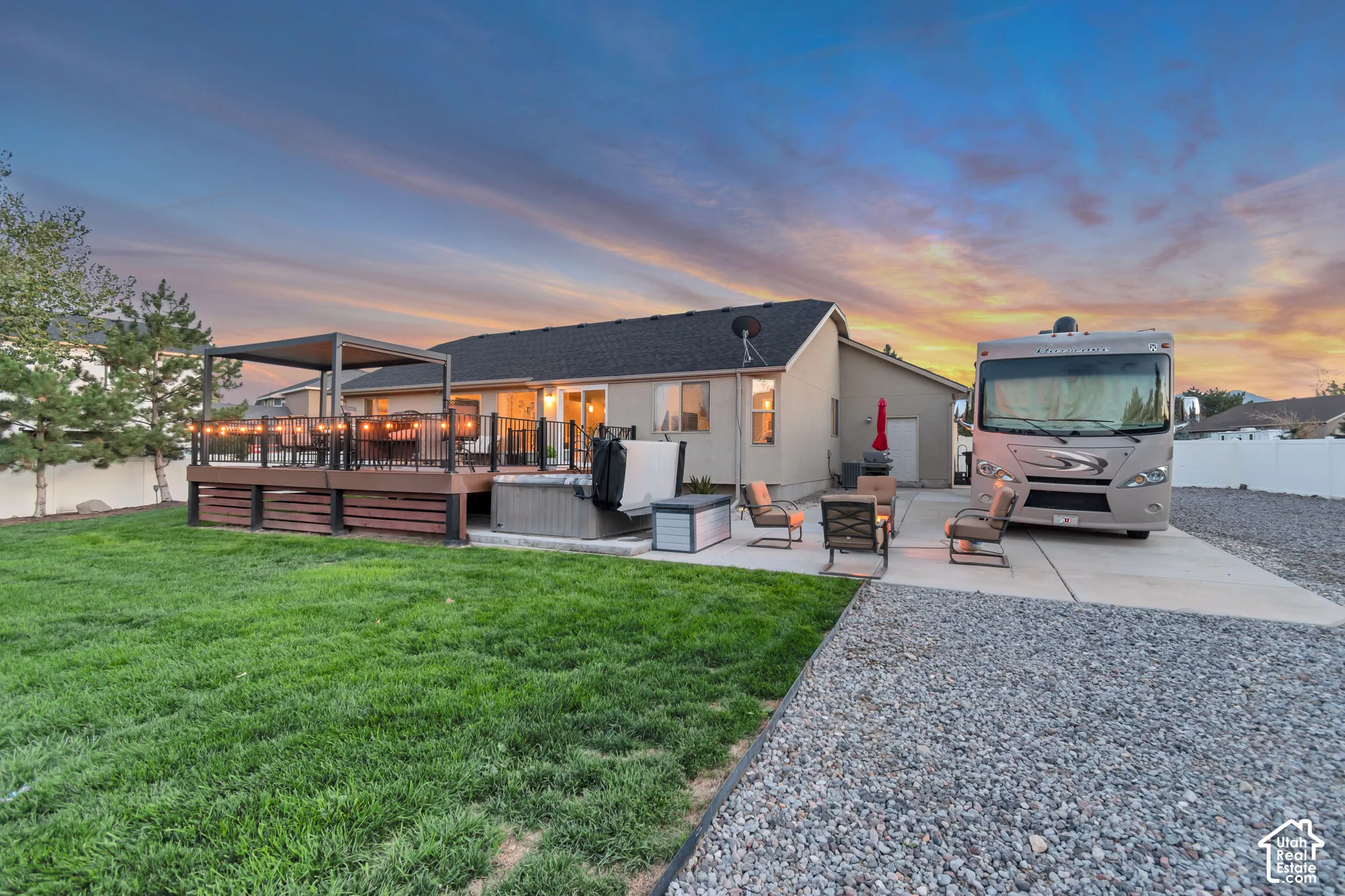 Expansive backyard featuring a manicured lawn, a large deck with a pergola, and a built-in hot tub