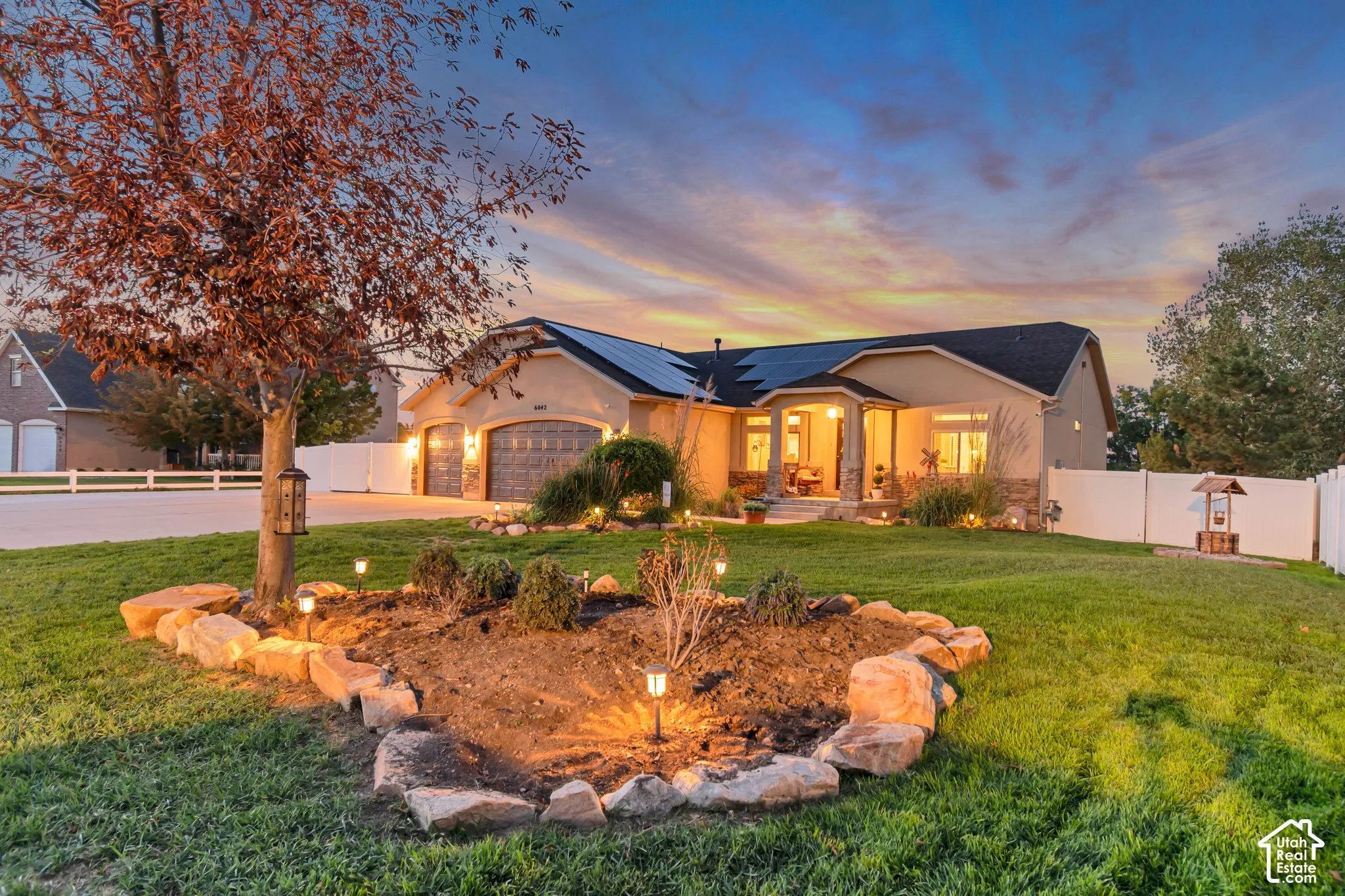 Stucco exterior with stone accents, covered front entry, and attached three-car garage