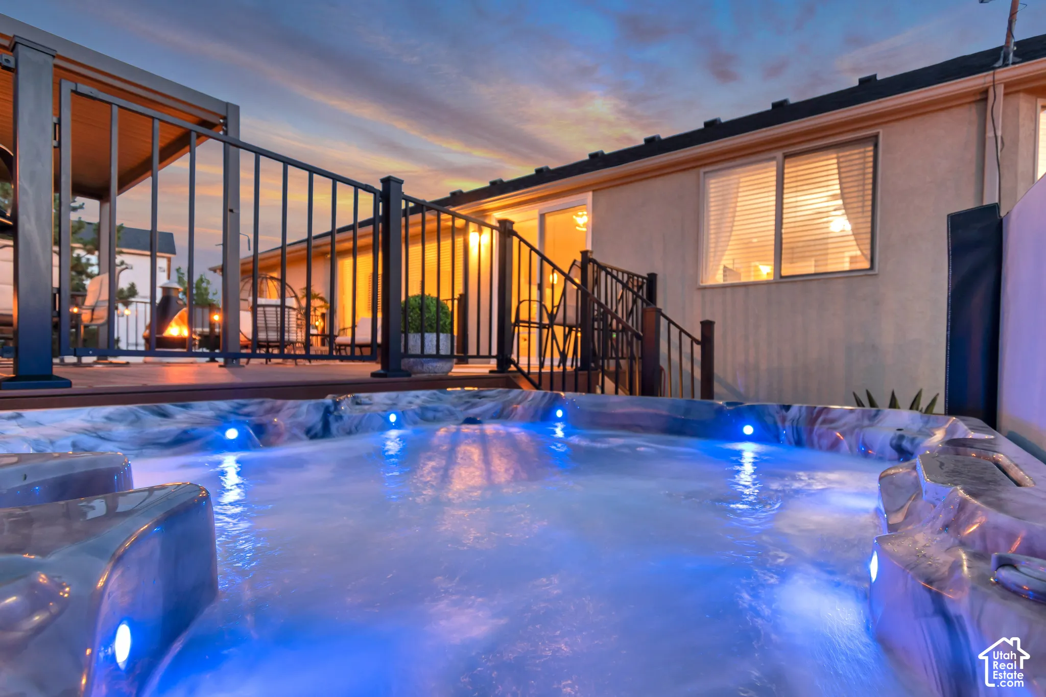 Built-in spa with integrated lighting, wood-finish decking, and black metal railings