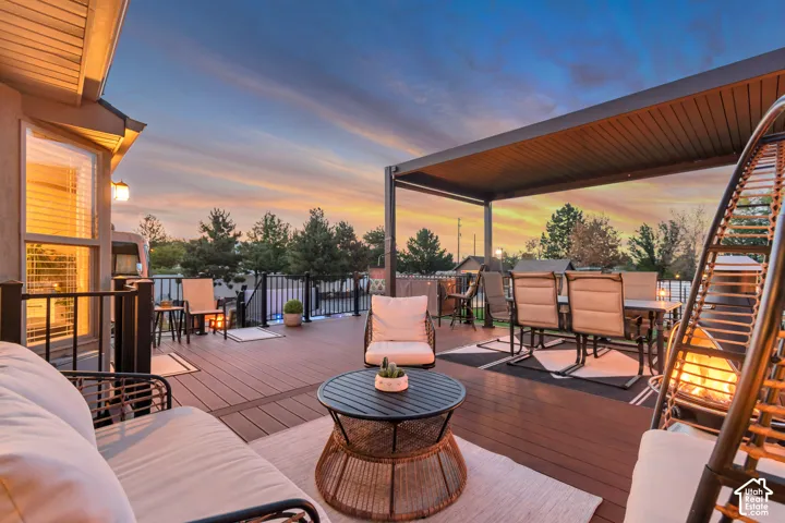 Multi-level composite deck featuring a slatted patio cover, black metal railings, and integrated outdoor lighting