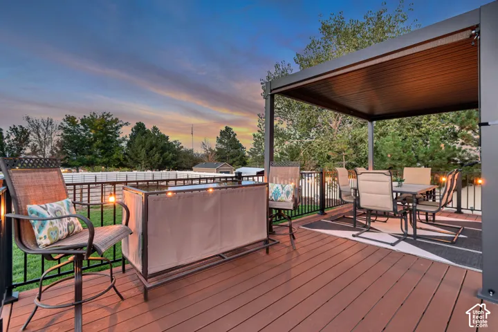 Expansive wood-finish deck with a metal pergola and black railing