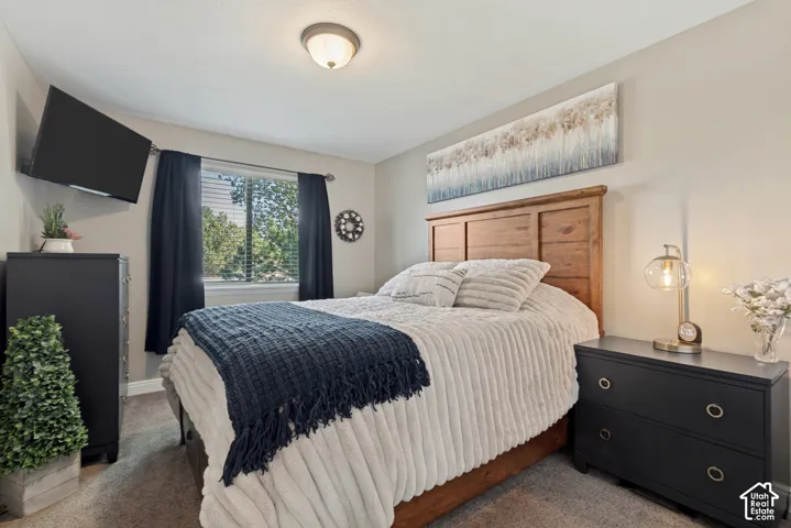 Recessed window with blinds, natural wood headboard, flush-mount ceiling light, and neutral wall tones