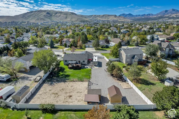 Two-story residence featuring a gravel driveway, rear deck, and fenced yard