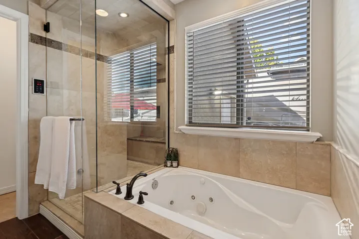 Tiled shower enclosure with a built-in bench, glass paneling, and a rain shower fixture