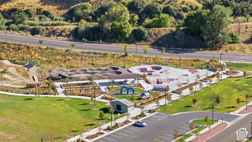Expansive green spaces, paved pathways, dedicated skate park, pump track, and a children's play area