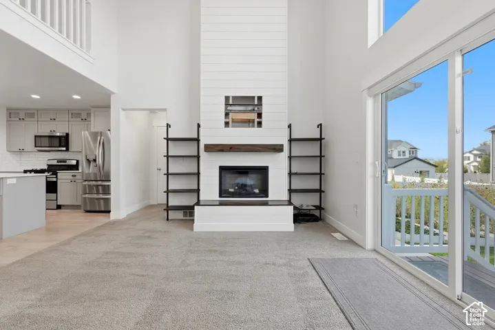 Two-story great room with shiplap fireplace surround and wood mantel