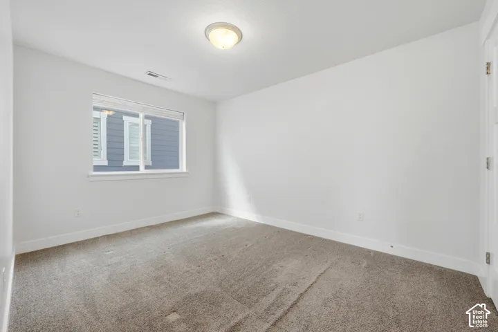Neutral wall paint, window with blinds, flush mount ceiling light, and carpeted flooring