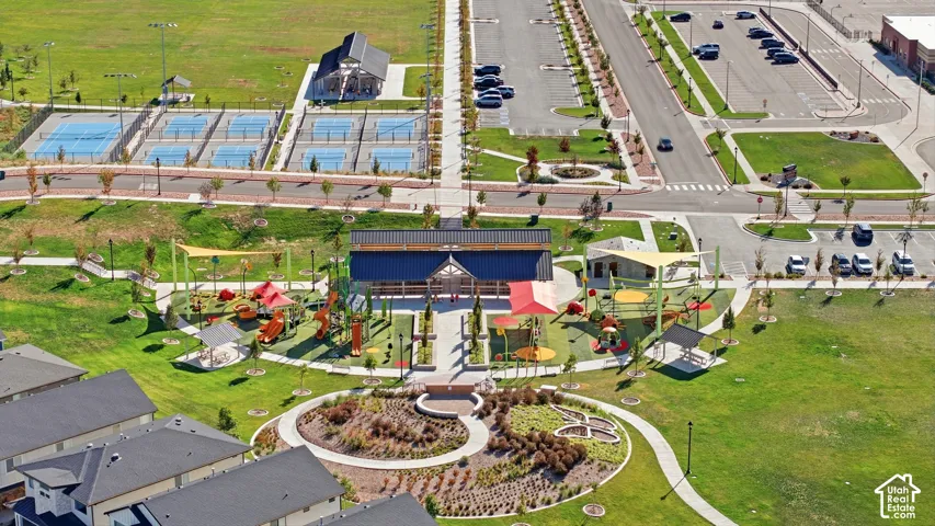 Expansive recreational area featuring multiple sports courts, a covered pavilion, a vibrant playground, and landscaped green spaces