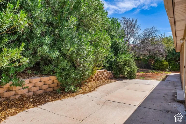 Paved concrete patio area with a stacked block retaining wall