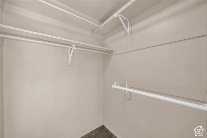 Neutral-toned walls with multiple white hanging rods and integrated shelving