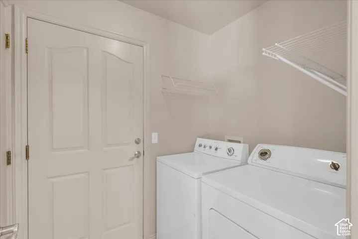 Laundry area featuring light-toned walls, white wire shelving, and a paneled door
