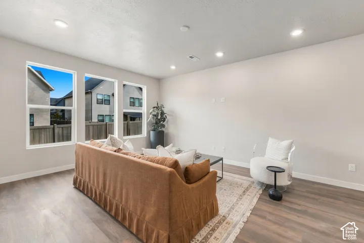 Recessed lighting, light-toned walls, wood-finish flooring, and multiple windows