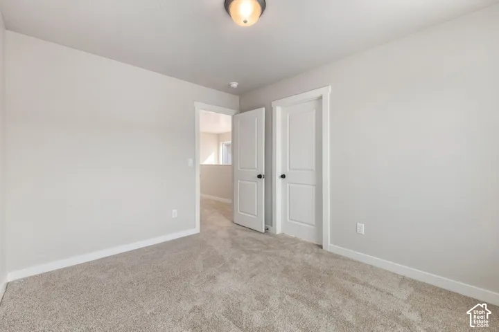 Plush carpet flooring, neutral wall paint, and overhead lighting