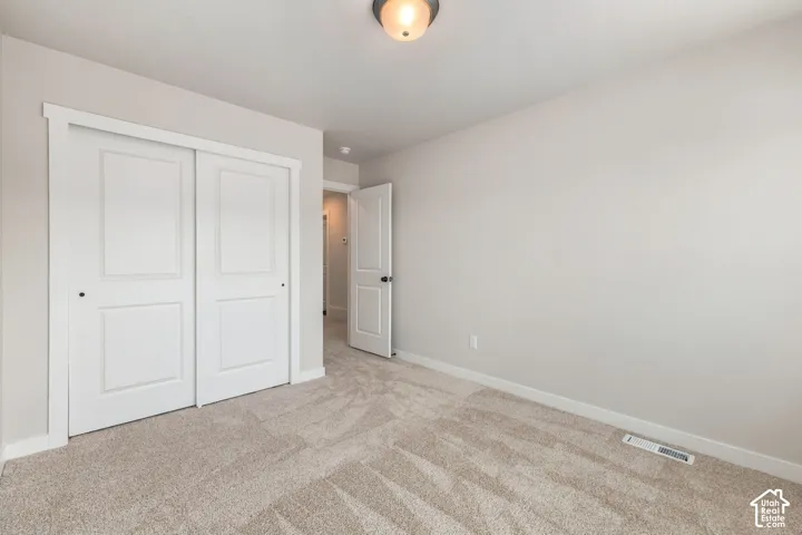 Plush carpet flooring, white sliding closet doors, and recessed lighting
