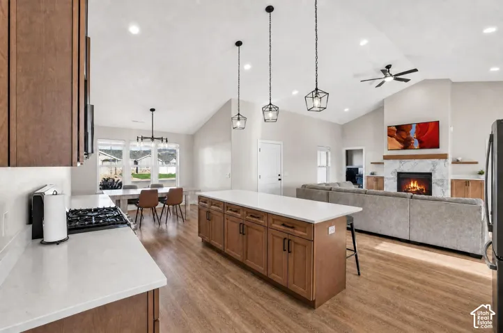 Open-concept living area featuring a vaulted ceiling, wood-finish flooring, and recessed lighting