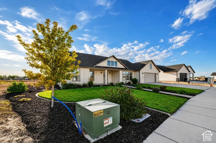 Single-story residence featuring a white vertical siding exterior, dark shingle roofing, and an attached two-car garage