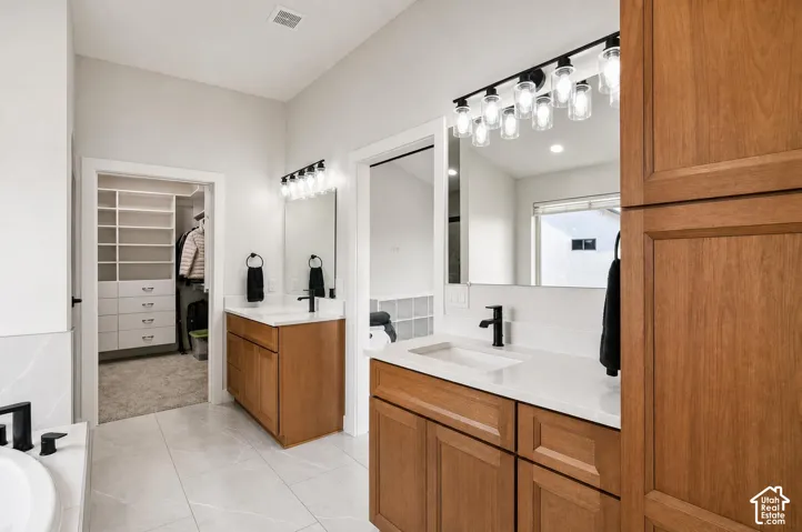 Dual wood-finish vanities with undermount sinks, stone countertops, and matte black fixtures